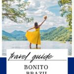 a woman in a yellow dress standing in water with her arms raised traveling in Bonito Brazil